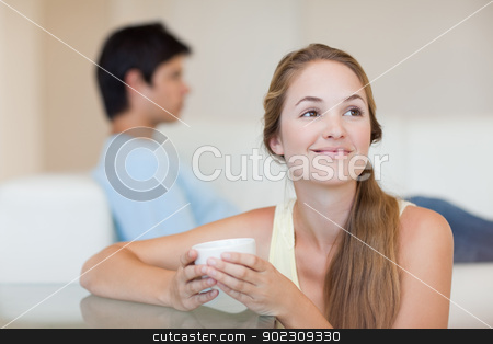 To use this stock image in your creative project, please select the size you need over to the right and click the "Add to Cart" button.
Your downloaded image will come with the Cutcaster watermark removed so don’t worry about the watermark you see on this page. Woman having a tea while her fiance is sitting on a sofa stock photo, Woman having a tea while her fiance is sitting on a sofa in their living room by Wavebreak Media
