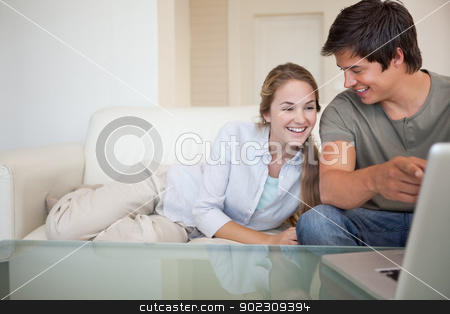 To use this stock image in your creative project, please select the size you need over to the right and click the "Add to Cart" button.
Your downloaded image will come with the Cutcaster watermark removed so don’t worry about the watermark you see on this page. Laughing couple using a notebook stock photo, Laughing couple using a notebook in their living room by Wavebreak Media