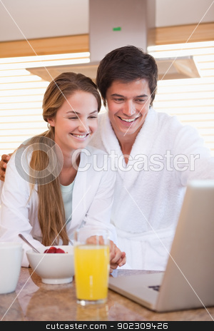 To use this stock image in your creative project, please select the size you need over to the right and click the "Add to Cart" button.
Your downloaded image will come with the Cutcaster watermark removed so don’t worry about the watermark you see on this page. Portrait of a couple having breakfast while using a notebook stock photo, Portrait of a couple having breakfast while using a notebook in their kitchen by Wavebreak Media