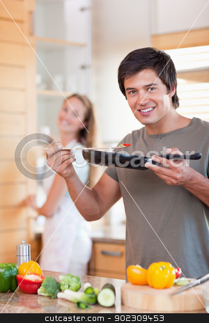 To use this stock image in your creative project, please select the size you need over to the right and click the "Add to Cart" button.
Your downloaded image will come with the Cutcaster watermark removed so don’t worry about the watermark you see on this page. Portrait of a young man cooking while his wife is washing the di stock photo, Portrait of a young man cooking while his wife is washing the dishes in their kitchen by Wavebreak Media
