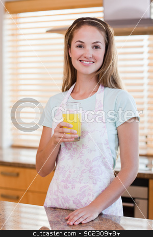 To use this stock image in your creative project, please select the size you need over to the right and click the "Add to Cart" button.
Your downloaded image will come with the Cutcaster watermark removed so don’t worry about the watermark you see on this page. Portrait of a young woman drinking orange juice stock photo, Portrait of a young woman drinking orange juice in her kitchen by Wavebreak Media