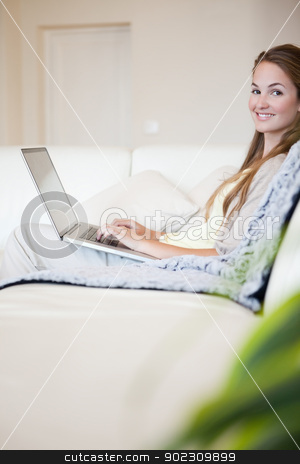 To use this stock image in your creative project, please select the size you need over to the right and click the "Add to Cart" button.
Your downloaded image will come with the Cutcaster watermark removed so don’t worry about the watermark you see on this page. Side view of smiling woman with her laptop sitting on the sofa stock photo, Side view of smiling young woman with her laptop sitting on the sofa by Wavebreak Media