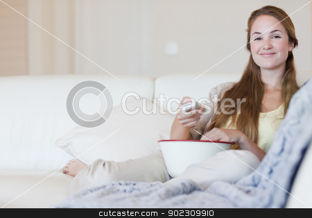 To use this stock image in your creative project, please select the size you need over to the right and click the "Add to Cart" button.
Your downloaded image will come with the Cutcaster watermark removed so don’t worry about the watermark you see on this page. Smiling woman enjoying a movie with a bowl of popcorn stock photo, Smiling young woman enjoying a movie with a bowl of popcorn by Wavebreak Media