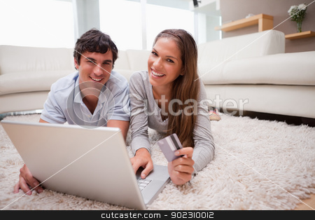 To use this stock image in your creative project, please select the size you need over to the right and click the "Add to Cart" button.
Your downloaded image will come with the Cutcaster watermark removed so don’t worry about the watermark you see on this page. Couple lying on the floor booking holidays online stock photo, Young couple lying on the floor booking holidays online by Wavebreak Media