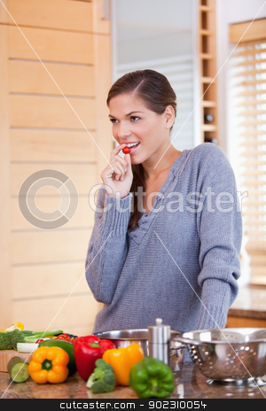 To use this stock image in your creative project, please select the size you need over to the right and click the "Add to Cart" button.
Your downloaded image will come with the Cutcaster watermark removed so don’t worry about the watermark you see on this page. Woman snacking a small tomato while preparing dinner stock photo, Young woman snacking a small tomato while preparing dinner by Wavebreak Media