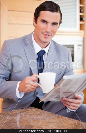To use this stock image in your creative project, please select the size you need over to the right and click the "Add to Cart" button.
Your downloaded image will come with the Cutcaster watermark removed so don’t worry about the watermark you see on this page. Businessman having coffee and reading news in the kitchen stock photo, Young businessman having coffee and reading news in the kitchen by Wavebreak Media