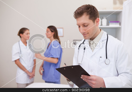 To use this stock image in your creative project, please select the size you need over to the right and click the "Add to Cart" button.
Your downloaded image will come with the Cutcaster watermark removed so don’t worry about the watermark you see on this page. Doctor reading patients record stock photo, Doctor reading patients record with colleagues behind him by Wavebreak Media