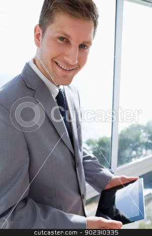 To use this stock image in your creative project, please select the size you need over to the right and click the "Add to Cart" button.
Your downloaded image will come with the Cutcaster watermark removed so don’t worry about the watermark you see on this page. Businessman standing in front of the window with his tablet stock photo, Young businessman standing in front of the window with his tablet by Wavebreak Media
