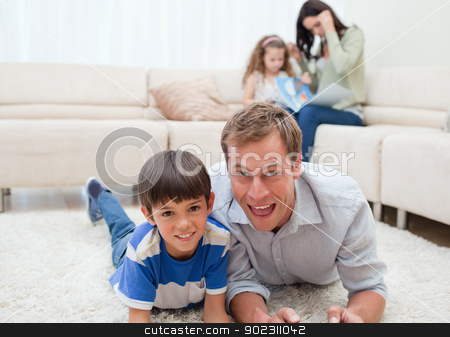 To use this stock image in your creative project, please select the size you need over to the right and click the "Add to Cart" button.
Your downloaded image will come with the Cutcaster watermark removed so don’t worry about the watermark you see on this page. Dad and son lying on the carpet stock photo, Dad and son lying on the carpet with mom and daughter behind them by Wavebreak Media