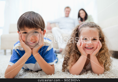 To use this stock image in your creative project, please select the size you need over to the right and click the "Add to Cart" button.
Your downloaded image will come with the Cutcaster watermark removed so don’t worry about the watermark you see on this page. Happy kids lying on the carpet with parents behind them stock photo, Happy smiling kids lying on the carpet with parents behind them by Wavebreak Media