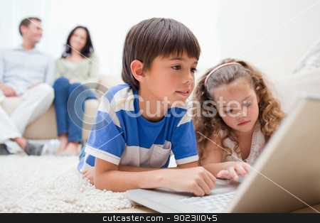 To use this stock image in your creative project, please select the size you need over to the right and click the "Add to Cart" button.
Your downloaded image will come with the Cutcaster watermark removed so don’t worry about the watermark you see on this page. Kids using laptop on the carpet with parents behind them stock photo, Happy kids using laptop on the carpet with parents behind them by Wavebreak Media