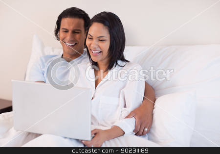 To use this stock image in your creative project, please select the size you need over to the right and click the "Add to Cart" button.
Your downloaded image will come with the Cutcaster watermark removed so don’t worry about the watermark you see on this page. Couple using their laptop while sitting on the bed stock photo, Young couple using their laptop while sitting on the bed by Wavebreak Media