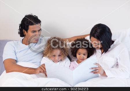 To use this stock image in your creative project, please select the size you need over to the right and click the "Add to Cart" button.
Your downloaded image will come with the Cutcaster watermark removed so don’t worry about the watermark you see on this page. Parents reading a book with their children stock photo, Young parents reading a book with their children by Wavebreak Media
