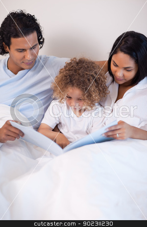 To use this stock image in your creative project, please select the size you need over to the right and click the "Add to Cart" button.
Your downloaded image will come with the Cutcaster watermark removed so don’t worry about the watermark you see on this page. Family sitting on the bed reading a story stock photo, Young family sitting on the bed reading a story by Wavebreak Media
