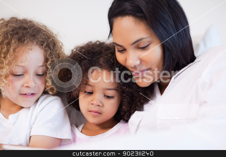 To use this stock image in your creative project, please select the size you need over to the right and click the "Add to Cart" button.
Your downloaded image will come with the Cutcaster watermark removed so don’t worry about the watermark you see on this page. Woman sitting on the bed with her daughters stock photo, Young woman sitting on the bed with her daughters by Wavebreak Media