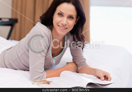 To use this stock image in your creative project, please select the size you need over to the right and click the "Add to Cart" button.
Your downloaded image will come with the Cutcaster watermark removed so don’t worry about the watermark you see on this page. Woman with magazine lying on the bed stock photo, Young woman with magazine lying on the bed by Wavebreak Media