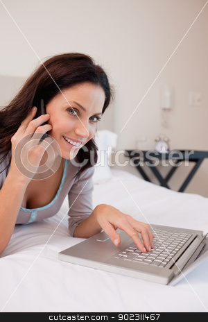 To use this stock image in your creative project, please select the size you need over to the right and click the "Add to Cart" button.
Your downloaded image will come with the Cutcaster watermark removed so don’t worry about the watermark you see on this page. Side view of smiling woman with laptop and phone on the bed stock photo, Side view of smiling young woman with laptop and phone on the bed by Wavebreak Media