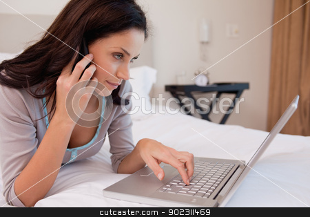 To use this stock image in your creative project, please select the size you need over to the right and click the "Add to Cart" button.
Your downloaded image will come with the Cutcaster watermark removed so don’t worry about the watermark you see on this page. Woman on the phone using laptop stock photo, Young woman on the phone using laptop by Wavebreak Media