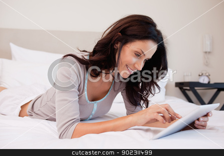 To use this stock image in your creative project, please select the size you need over to the right and click the "Add to Cart" button.
Your downloaded image will come with the Cutcaster watermark removed so don’t worry about the watermark you see on this page. Smiling woman with tablet on her bed stock photo, Smiling young woman with tablet on her bed by Wavebreak Media