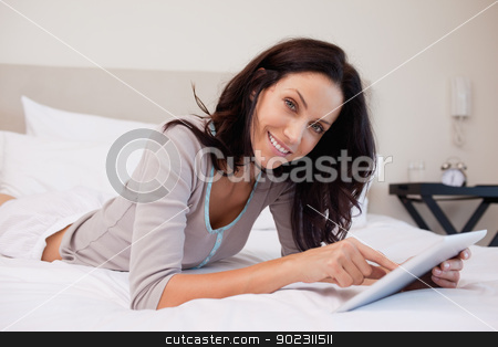 To use this stock image in your creative project, please select the size you need over to the right and click the "Add to Cart" button.
Your downloaded image will come with the Cutcaster watermark removed so don’t worry about the watermark you see on this page. Smiling woman with tablet on the bed stock photo, Smiling young woman with tablet on the bed by Wavebreak Media