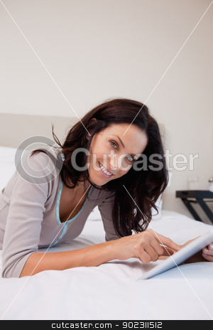 To use this stock image in your creative project, please select the size you need over to the right and click the "Add to Cart" button.
Your downloaded image will come with the Cutcaster watermark removed so don’t worry about the watermark you see on this page. Smiling woman with tablet in the bedroom stock photo, Smiling young woman with tablet in the bedroom by Wavebreak Media