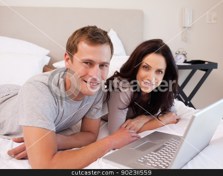 To use this stock image in your creative project, please select the size you need over to the right and click the "Add to Cart" button.
Your downloaded image will come with the Cutcaster watermark removed so don’t worry about the watermark you see on this page. Happy couple using laptop on the bed together stock photo, Happy young couple using laptop on the bed together by Wavebreak Media