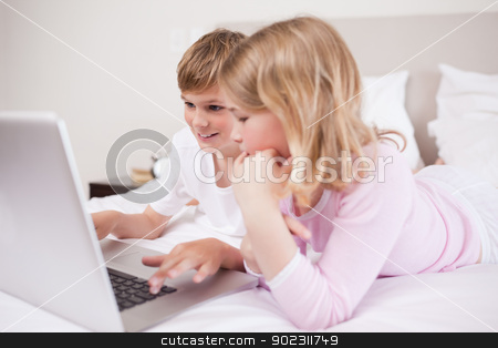To use this stock image in your creative project, please select the size you need over to the right and click the "Add to Cart" button.
Your downloaded image will come with the Cutcaster watermark removed so don’t worry about the watermark you see on this page. Smiling children using a laptop stock photo, Smiling children using a laptop in a bedroom by Wavebreak Media