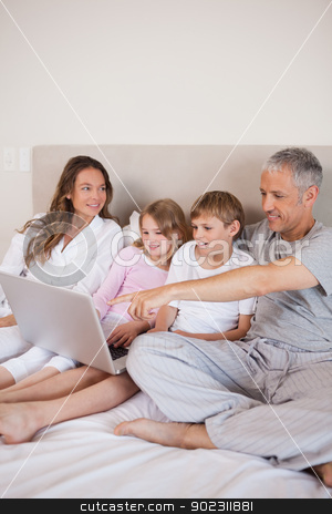 To use this stock image in your creative project, please select the size you need over to the right and click the "Add to Cart" button.
Your downloaded image will come with the Cutcaster watermark removed so don’t worry about the watermark you see on this page. Portrait of a family using a notebook stock photo, Portrait of a family using a notebook in a bedroom by Wavebreak Media