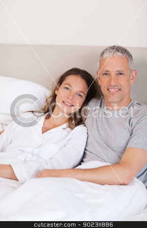To use this stock image in your creative project, please select the size you need over to the right and click the "Add to Cart" button.
Your downloaded image will come with the Cutcaster watermark removed so don’t worry about the watermark you see on this page. Portrait of a couple lying on a bed stock photo, Portrait of a couple lying on a bed while looking at the camera by Wavebreak Media