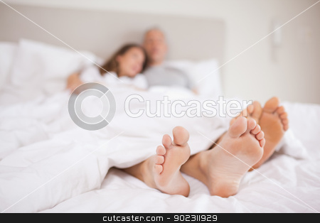 To use this stock image in your creative project, please select the size you need over to the right and click the "Add to Cart" button.
Your downloaded image will come with the Cutcaster watermark removed so don’t worry about the watermark you see on this page. Lovely couple lying in a bed stock photo, Lovely couple lying in a bed with the camera focus on their feed by Wavebreak Media