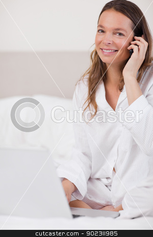 To use this stock image in your creative project, please select the size you need over to the right and click the "Add to Cart" button.
Your downloaded image will come with the Cutcaster watermark removed so don’t worry about the watermark you see on this page. Portrait of a woman using a notebook while making a phone call stock photo, Portrait of a woman using a notebook while making a phone call in her bedroom by Wavebreak Media