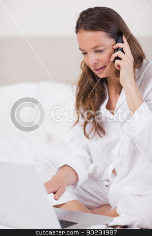 To use this stock image in your creative project, please select the size you need over to the right and click the "Add to Cart" button.
Your downloaded image will come with the Cutcaster watermark removed so don’t worry about the watermark you see on this page. Portrait of a quiet woman using a laptop while making a phone ca stock photo, Portrait of a quiet woman using a laptop while making a phone call in her bedroom by Wavebreak Media
