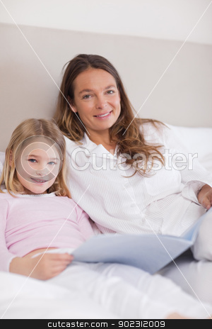 To use this stock image in your creative project, please select the size you need over to the right and click the "Add to Cart" button.
Your downloaded image will come with the Cutcaster watermark removed so don’t worry about the watermark you see on this page. Portrait of a smiling girl reading a book with her mother stock photo, Portrait of a smiling girl reading a book with her mother in a bedroom by Wavebreak Media