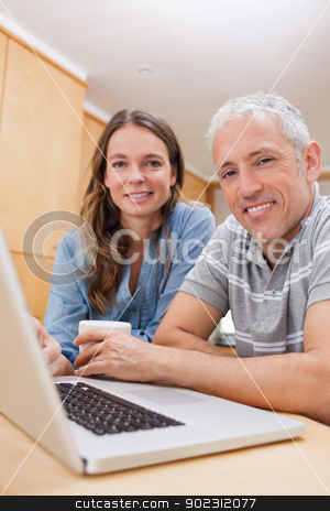 To use this stock image in your creative project, please select the size you need over to the right and click the "Add to Cart" button.
Your downloaded image will come with the Cutcaster watermark removed so don’t worry about the watermark you see on this page. Portrait of a couple using a laptop while having tea stock photo, Portrait of a couple using a laptop while having tea in their kitchen by Wavebreak Media