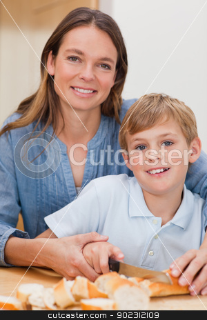 To use this stock image in your creative project, please select the size you need over to the right and click the "Add to Cart" button.
Your downloaded image will come with the Cutcaster watermark removed so don’t worry about the watermark you see on this page. Portrait of a mother slicing bread with her son stock photo, Portrait of a mother slicing bread with her son in a kitchen by Wavebreak Media