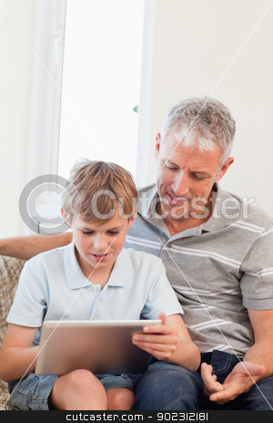 To use this stock image in your creative project, please select the size you need over to the right and click the "Add to Cart" button.
Your downloaded image will come with the Cutcaster watermark removed so don’t worry about the watermark you see on this page. Portrait of a father and his son using a tablet computer stock photo, Portrait of a father and his son using a tablet computer in a living room by Wavebreak Media