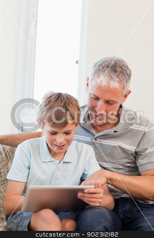 To use this stock image in your creative project, please select the size you need over to the right and click the "Add to Cart" button.
Your downloaded image will come with the Cutcaster watermark removed so don’t worry about the watermark you see on this page. Portrait of a happy father and his son using a tablet computer stock photo, Portrait of a happy father and his son using a tablet computer in a living room by Wavebreak Media