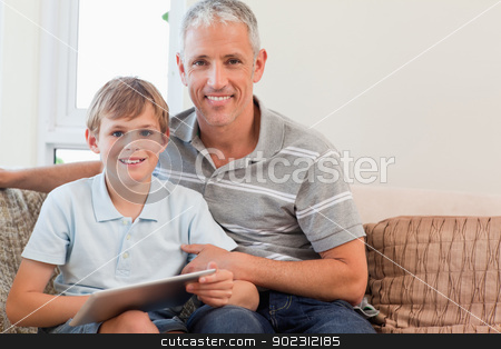 To use this stock image in your creative project, please select the size you need over to the right and click the "Add to Cart" button.
Your downloaded image will come with the Cutcaster watermark removed so don’t worry about the watermark you see on this page. Smiling father and his son using a tablet computer stock photo, Smiling father and his son using a tablet computer in a living room by Wavebreak Media