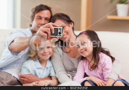To use this stock image in your creative project, please select the size you need over to the right and click the "Add to Cart" button.
Your downloaded image will come with the Cutcaster watermark removed so don’t worry about the watermark you see on this page. Happy father taking a picture of his family stock photo, Happy father taking a picture of his family in a living room by Wavebreak Media