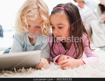 To use this stock image in your creative project, please select the size you need over to the right and click the "Add to Cart" button.
Your downloaded image will come with the Cutcaster watermark removed so don’t worry about the watermark you see on this page. Children using a tablet computer while their parents are in the stock photo, Children using a tablet computer while their parents are in the background in a living room by Wavebreak Media