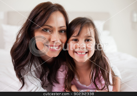To use this stock image in your creative project, please select the size you need over to the right and click the "Add to Cart" button.
Your downloaded image will come with the Cutcaster watermark removed so don’t worry about the watermark you see on this page. Girl and her mother lying on a bed stock photo, Girl and her mother lying on a bed while looking at the camera by Wavebreak Media