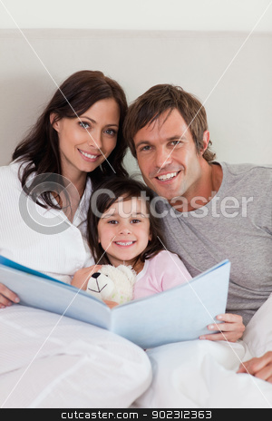 To use this stock image in your creative project, please select the size you need over to the right and click the "Add to Cart" button.
Your downloaded image will come with the Cutcaster watermark removed so don’t worry about the watermark you see on this page. Portrait of parents reading a story to their daughter stock photo, Portrait of parents reading a story to their daughter in a bedroom by Wavebreak Media