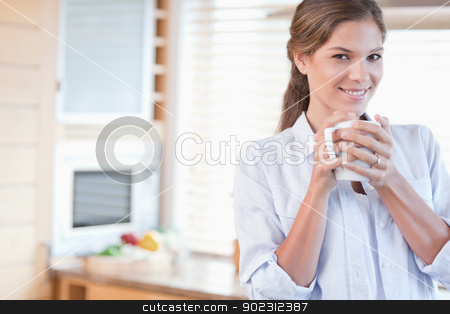 To use this stock image in your creative project, please select the size you need over to the right and click the "Add to Cart" button.
Your downloaded image will come with the Cutcaster watermark removed so don’t worry about the watermark you see on this page. Smiling woman holding a cup of coffee stock photo, Smiling woman holding a cup of coffee in her kitchen by Wavebreak Media