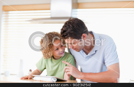 To use this stock image in your creative project, please select the size you need over to the right and click the "Add to Cart" button.
Your downloaded image will come with the Cutcaster watermark removed so don’t worry about the watermark you see on this page. Young boy and his father using a tablet computer stock photo, Young boy and his father using a tablet computer in their kitchen by Wavebreak Media