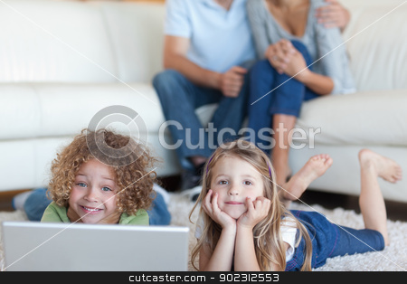 To use this stock image in your creative project, please select the size you need over to the right and click the "Add to Cart" button.
Your downloaded image will come with the Cutcaster watermark removed so don’t worry about the watermark you see on this page. Cute children using a laptop while their parents are watching stock photo, Cute children using a laptop while their parents are watching in their living room by Wavebreak Media