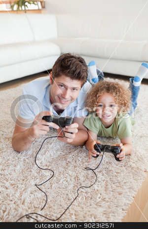 To use this stock image in your creative project, please select the size you need over to the right and click the "Add to Cart" button.
Your downloaded image will come with the Cutcaster watermark removed so don’t worry about the watermark you see on this page. Portrait of a boy and his father playing video games stock photo, Portrait of a boy and his father playing video games while lying on a carpet by Wavebreak Media