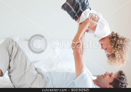 To use this stock image in your creative project, please select the size you need over to the right and click the "Add to Cart" button.
Your downloaded image will come with the Cutcaster watermark removed so don’t worry about the watermark you see on this page. Side view of father lifting child on bed stock photo, Side view of father lifting smiling child on bed by Wavebreak Media