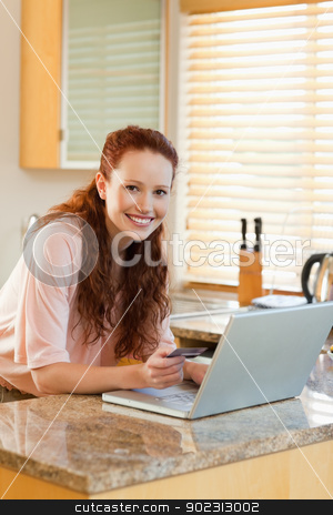 To use this stock image in your creative project, please select the size you need over to the right and click the "Add to Cart" button.
Your downloaded image will come with the Cutcaster watermark removed so don’t worry about the watermark you see on this page. Smiling woman in the kitchen booking holiday online stock photo, Smiling young woman in the kitchen booking holiday online by Wavebreak Media