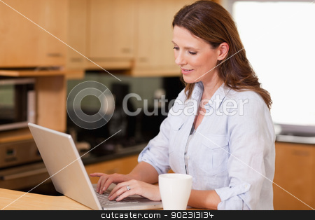To use this stock image in your creative project, please select the size you need over to the right and click the "Add to Cart" button.
Your downloaded image will come with the Cutcaster watermark removed so don’t worry about the watermark you see on this page. Woman in the kitchen using her laptop stock photo, Woman with cup in the kitchen using her laptop by Wavebreak Media