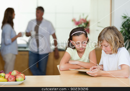 To use this stock image in your creative project, please select the size you need over to the right and click the "Add to Cart" button.
Your downloaded image will come with the Cutcaster watermark removed so don’t worry about the watermark you see on this page. Children using tablet in the kitchen with parents behind them stock photo, Children using tablet in the kitchen with their parents behind them by Wavebreak Media